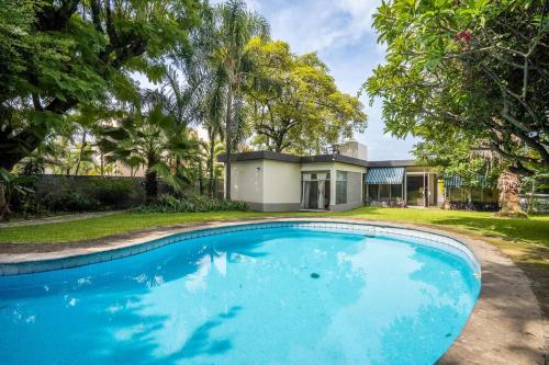 a large blue swimming pool in front of a house at Family-Friendly Oasis with Pool in Cuernavaca in Cuernavaca