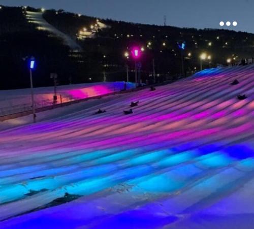 a skating rink with blue and purple lights at night at Majestic Lake Front Chalet in Tobyhanna