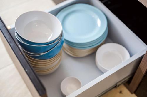 a drawer filled with blue and white plates and bowls at come home pool villa cha-am in Phetchaburi