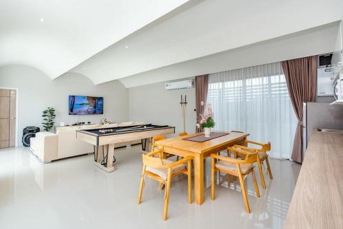 a living room with a ping pong table and chairs at come home pool villa cha-am in Phetchaburi