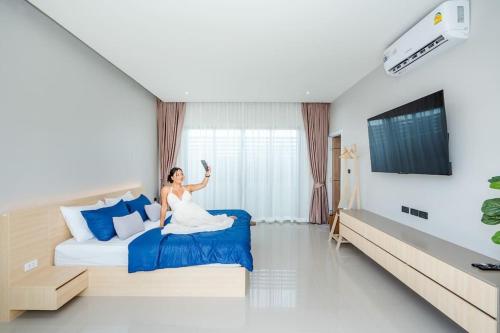 a bride sitting on a bed in a hotel room at come home pool villa cha-am in Phetchaburi