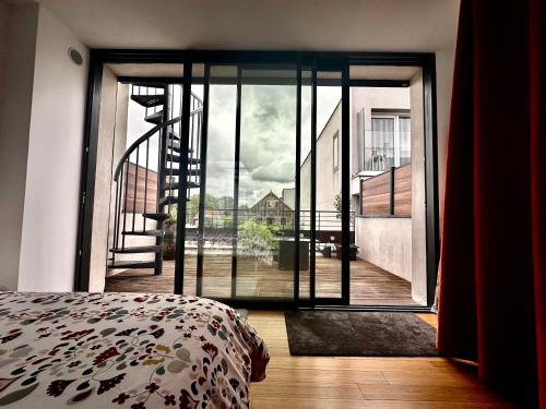 - une chambre avec une grande porte en verre donnant sur un balcon dans l'établissement Libre Pensée, à Romainville