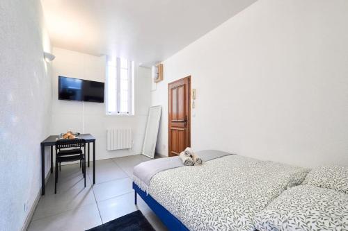 une chambre avec un lit, une table et une télévision dans l'établissement Le Petit Marceaux - T1 - Confort, à Reims