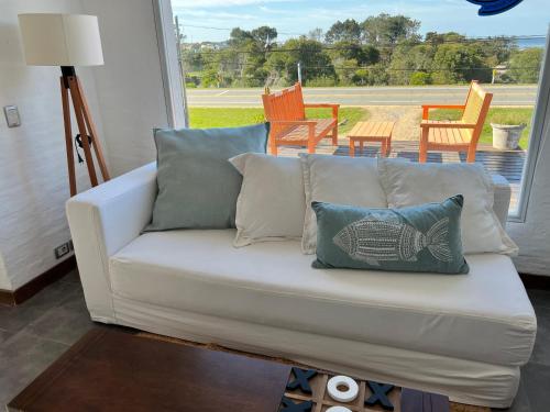 un sofá blanco con almohadas en la sala de estar en IPB La Juanita, en José Ignacio