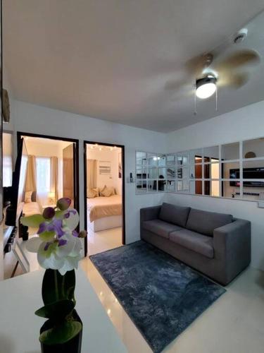 a living room with a couch and a bedroom at Palawan Cozy 2BR w Washer, Dryer, Gym, Pool for 6 in Puerto Princesa City