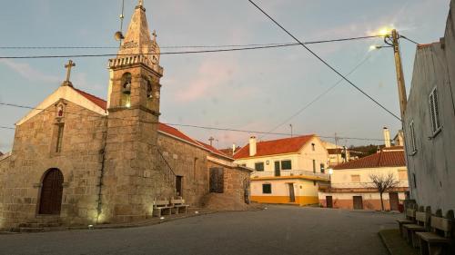 an old stone church with a steeple on a street at Sofiamarholidays O Cantinho da Avó Bina in Moita