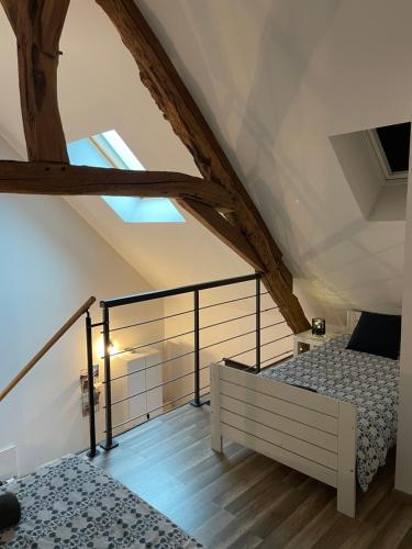 - une chambre mansardée avec 2 lits et une fenêtre dans l'établissement Loft Chez Guillaume, à Bouleurs