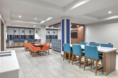 a dining room with chairs and tables and a cafeteria at Holiday Inn Express Hotel & Suites Winnie by IHG in Winnie