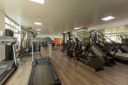 a gym with several treadmills and machines in it at Ritz Lagoa da Anta Hotel & SPA in Maceió