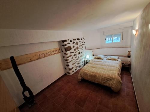 a small bedroom with a bed and a window at Tu Casita en el Pantano de San Juan in San Martín de Valdeiglesias