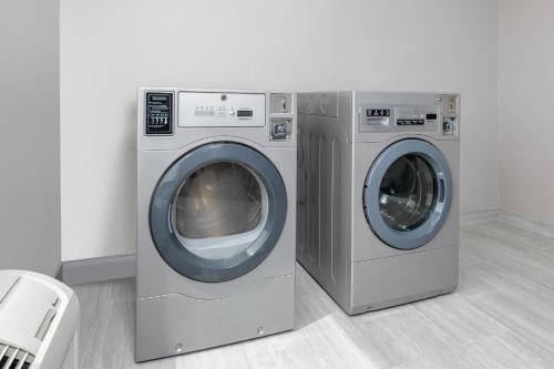 two washing machines sitting next to each other in a room at Holiday Inn Express Hotel & Suites Winnie by IHG in Winnie