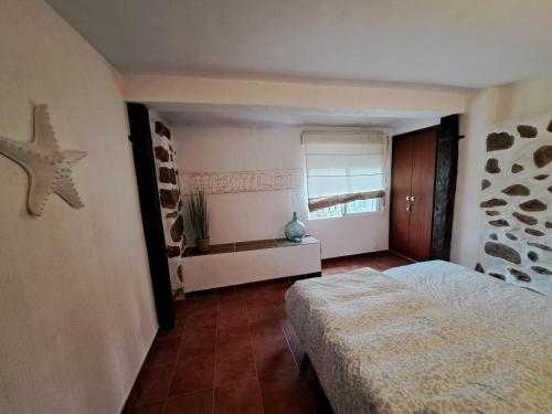 a bedroom with a bed and a window at Tu Casita en el Pantano de San Juan in San Martín de Valdeiglesias