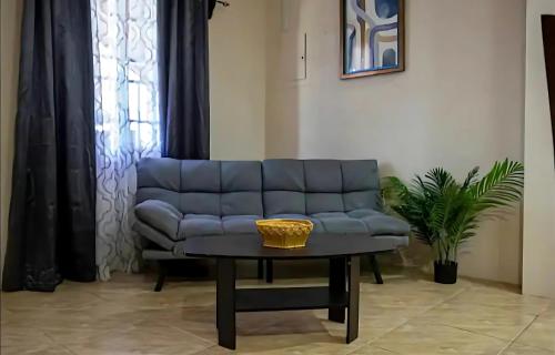 a living room with a blue couch and a table at Casa De Llewellyn's Apartments in Kelly Village