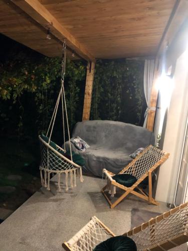 a porch with two swings and a bed at Domek w Pieninach Apartament Pałacowy Liliana in Krościenko