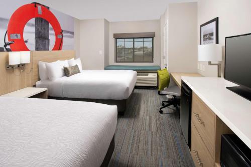 a hotel room with two beds and a flat screen tv at Best Western Beachside Inn in South Padre Island