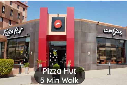 a pizza hut min walk sign in front of a building at Oranger Family House Marrakech City Center, Private Large House, Terasse Garden View, Free Parking in Marrakech