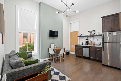 a living room with a couch and a kitchen at Neat Suites, The Baldwin Flatts in Covington