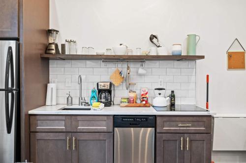 a kitchen with a sink and a refrigerator at Neat Suites, The Baldwin Flatts in Covington