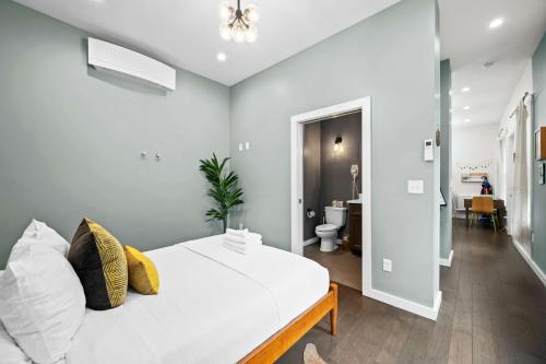 a bedroom with a white bed and a bathroom at Neat Suites, The Baldwin Flatts in Covington