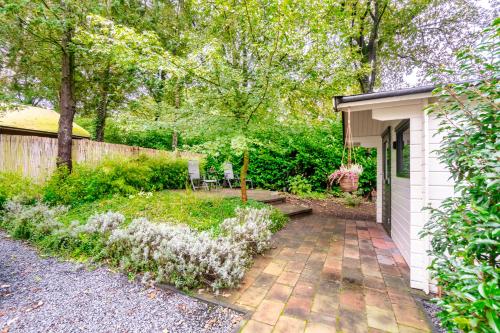 a garden with a patio and a shed at Bos Chalet Natura - Rust en Natuur op de Veluwe Putten in Putten