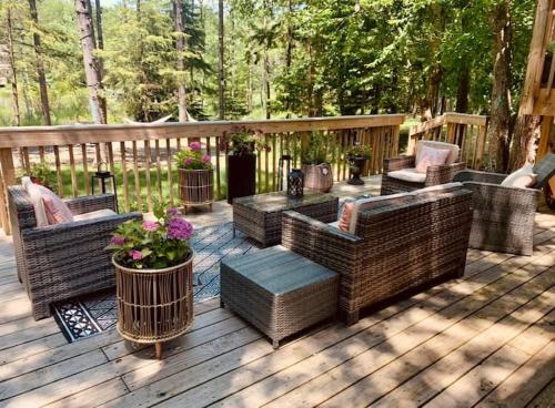 una terrazza in legno con tavolo e sedie in vimini di Majestic Lake Front Chalet a Tobyhanna