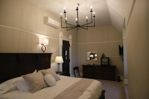 a bedroom with a large bed and a chandelier at Mon Bijou in Oconomowoc