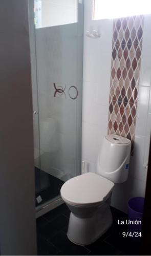 a bathroom with a white toilet and a shower at La trinidad in Lemos