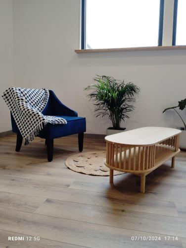 a living room with a coffee table and a chair at Gite de la salamandre in Pléguien