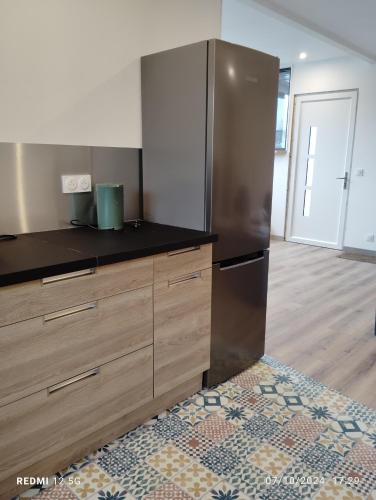 a kitchen with a large stainless steel refrigerator at Gite de la salamandre in Pléguien