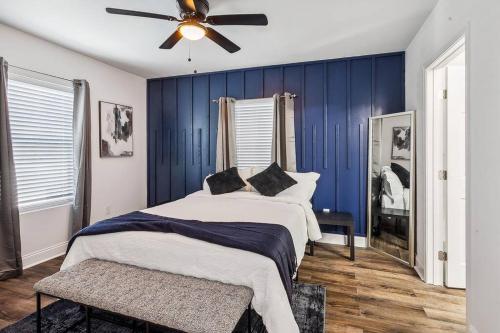 a bedroom with blue walls and a bed with a ceiling fan at Charming NOLA Oasis in New Orleans