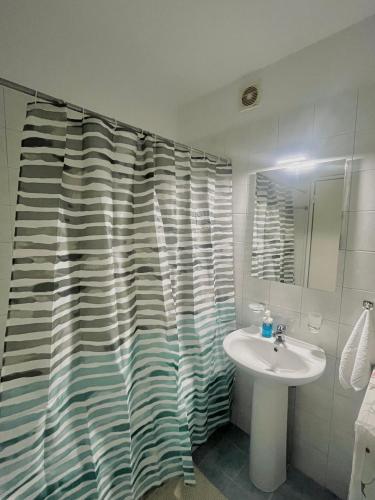 a bathroom with a sink and a shower curtain at Family House Dim in Ioannina