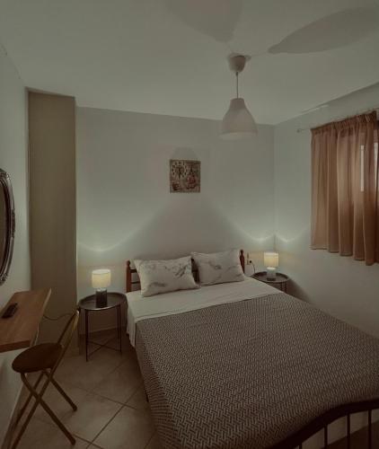 a bedroom with a bed and two lamps and a table at Family House Dim in Ioannina