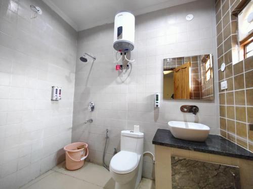 a bathroom with a toilet and a sink and a mirror at Castle INN in Dehradun