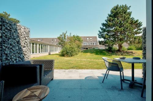 un patio con tavolo, tavolo e sedie di Amelander Kaap 117 a Hollum