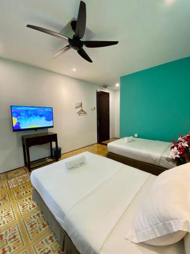 a room with two beds and a flat screen tv at Bayu Bayu Hotel by Soft Loft in Tanjung Bungah