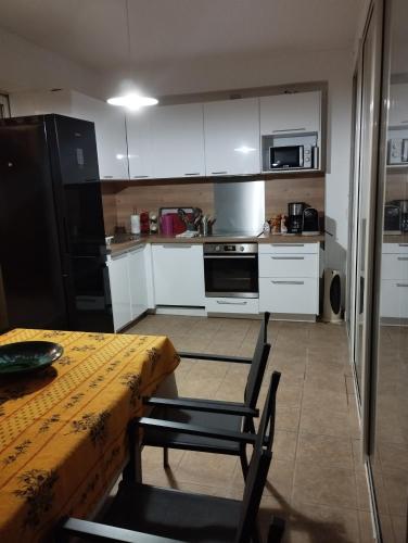a kitchen with white cabinets and a table with chairs at Maison à la plage.7 couchages in Borgo