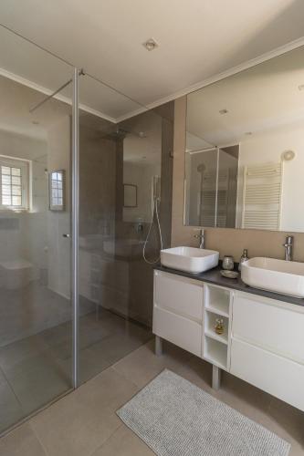 a bathroom with two sinks and a glass shower at Villa Penedo in São Domingos de Rana