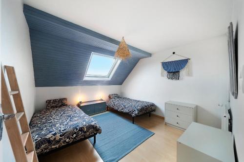 une chambre mansardée avec deux lits et une fenêtre dans l'établissement Le Beau Marchais - Proche centre & Spacieux, à Dijon