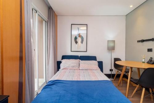a bedroom with a blue bed and a table at LFlats no Hotel Stella Vega (EX-Mercury Ibirapuera) in Sao Paulo