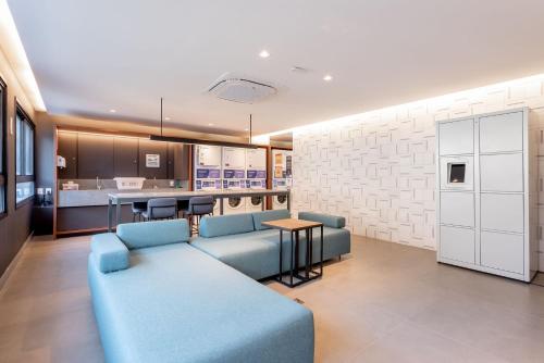 a living room with a blue couch and a kitchen at GO Rio Branco by LikeHome in Porto Alegre