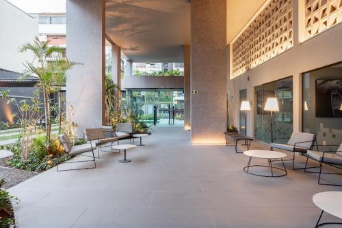 a lobby with tables and chairs in a building at GO Rio Branco by LikeHome in Porto Alegre