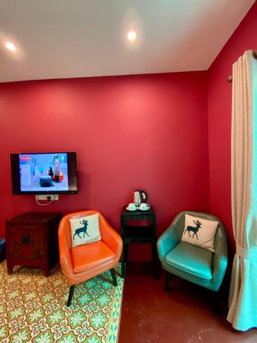 a living room with two chairs and a flat screen tv at Bayu Bayu Hotel by Soft Loft in Tanjung Bungah