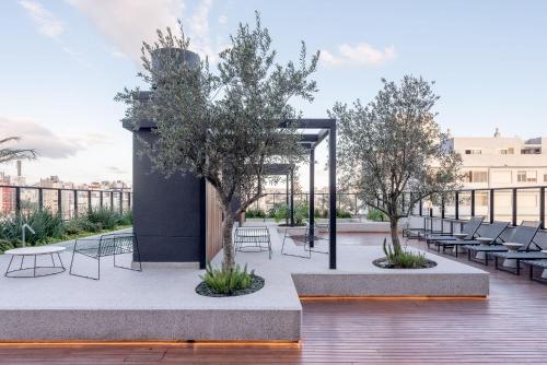 a courtyard with chairs and trees on a building at GO Rio Branco by LikeHome in Porto Alegre