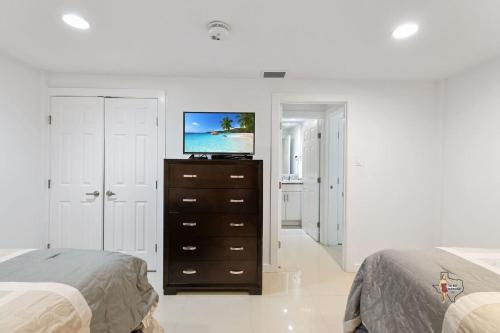 a bedroom with two beds and a television on a dresser at Bahia Mar Solare Beachfront Resort Condos with Two Pools in South Padre Island