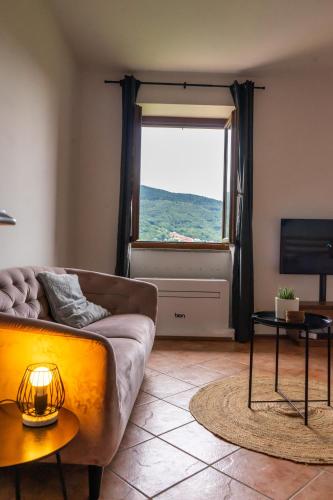 a living room with a couch and a window at Studio ROSA in Miagliano
