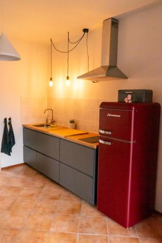 a kitchen with a red refrigerator and a sink at Studio ROSA in Miagliano