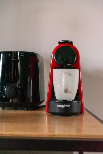 a red coffee maker sitting on top of a table at Studio ROSA in Miagliano
