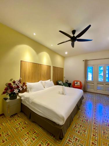 a bedroom with a large bed with a ceiling fan at Bayu Bayu Hotel by Soft Loft in Tanjung Bungah