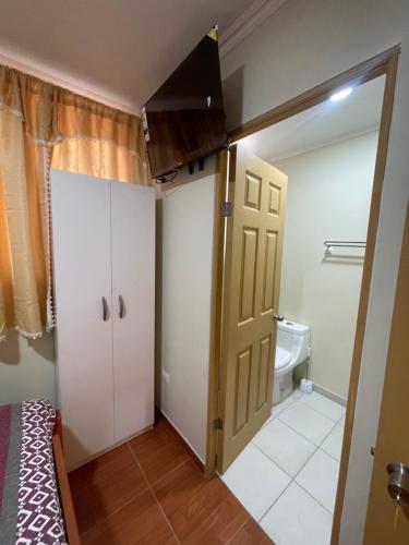 a room with a bathroom with a toilet and a door at Apartamentos Lourdes in Antofagasta