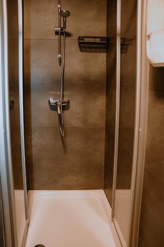 a shower with a glass door in a bathroom at Angelis Pension Frankfurt Airport in Kelsterbach
